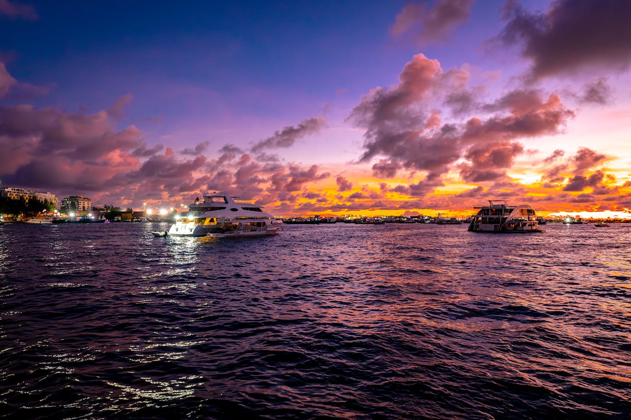 Home Stunning sunset view of luxury yachts sailing on the calm waters of the Maldives.
